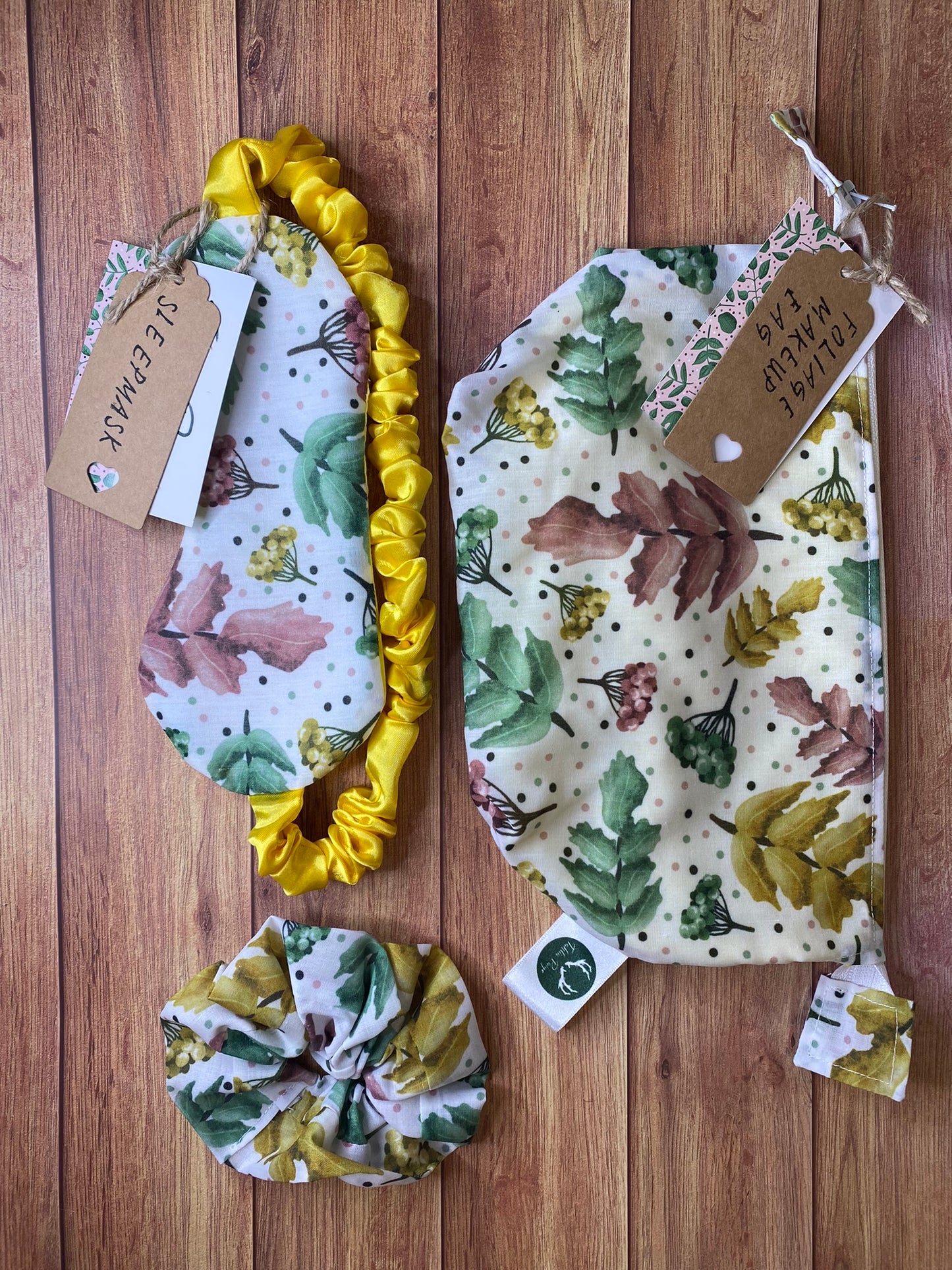pretty foliage giftset including makeup bag, sleepmask and scrunchie on wooden background