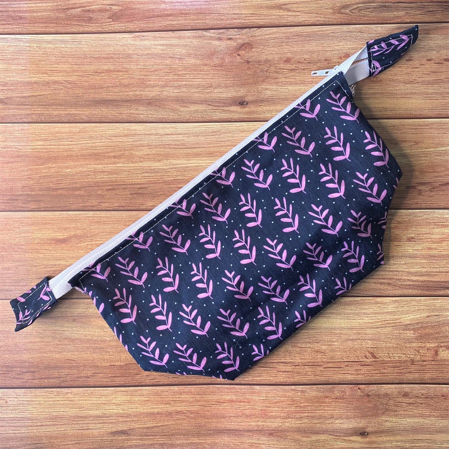 Dark blue patterned makeup bag for cosmetic storage on a wooden background