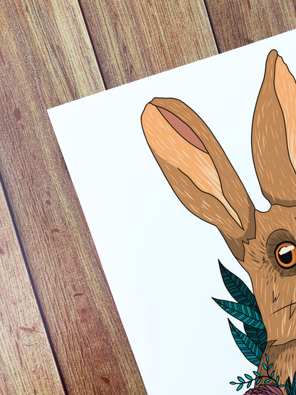 A corner of an art print that shows a close up of an illustration of a hare with some leaves behind it. Drawn in a digital style.