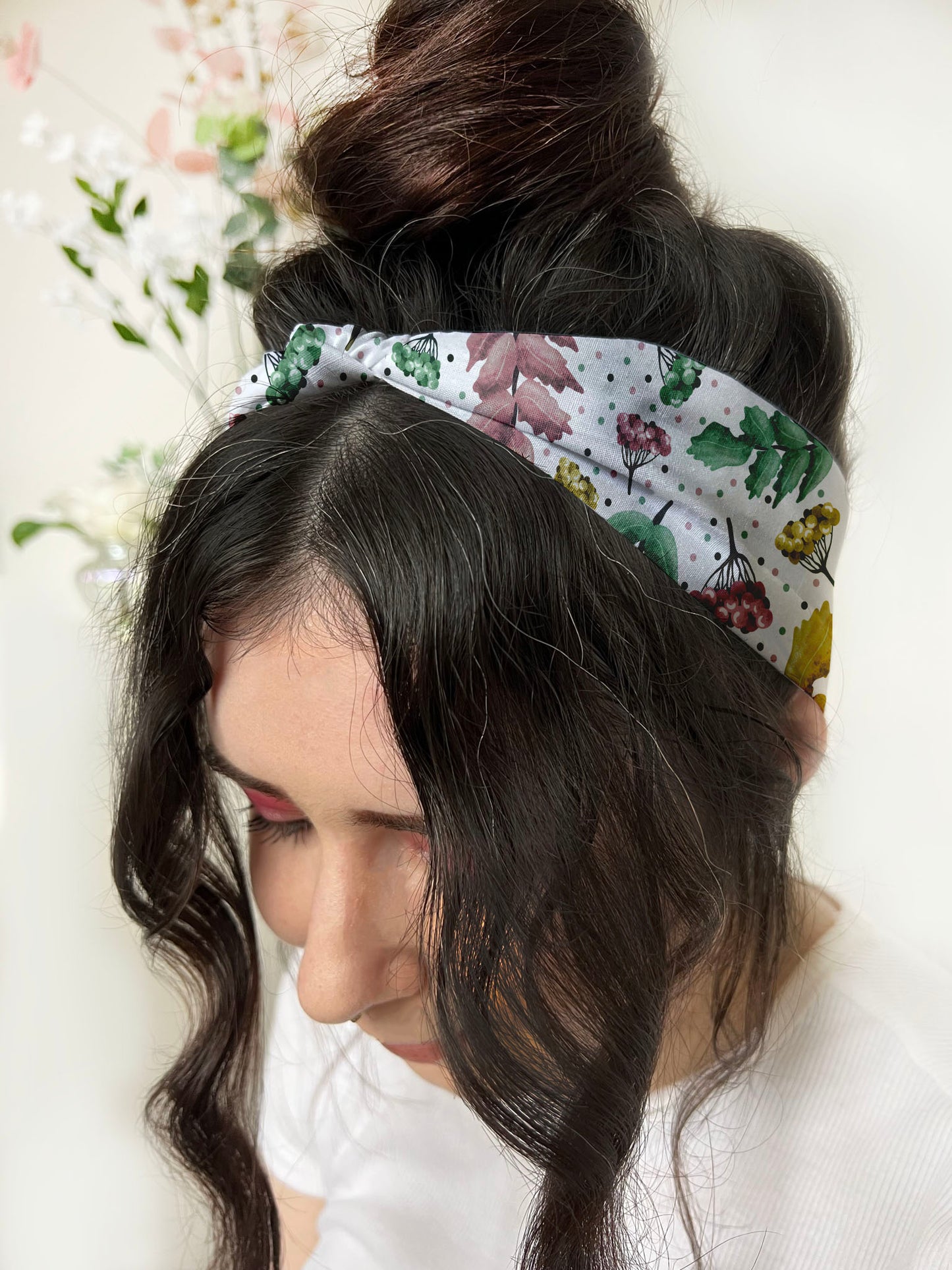 dark haired girl wears pretty foliage patterned headband, ideal gifts for her in fashion now