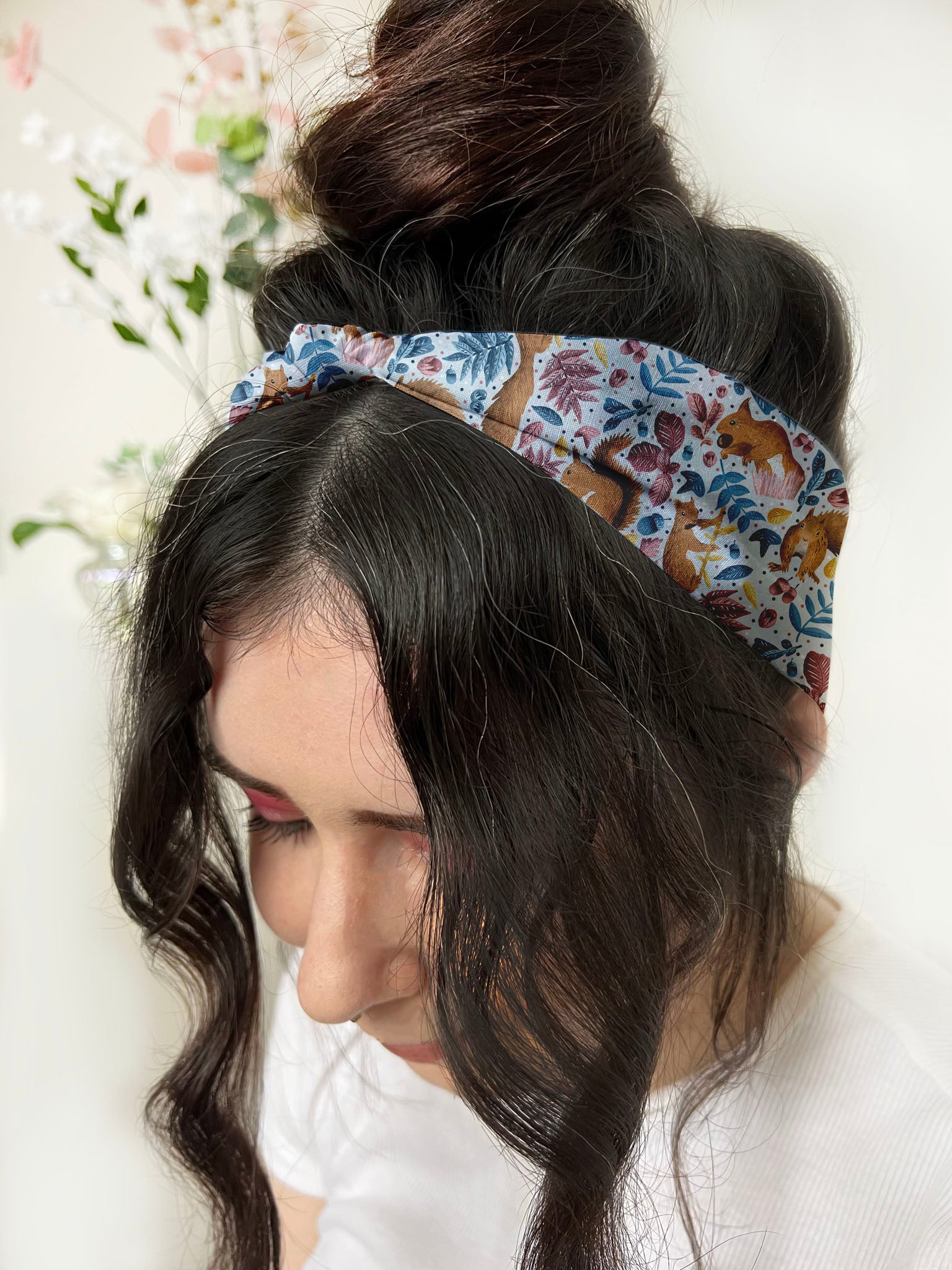 dark haired girl wears red squirrel patterned headband, a great woodland hair accessories gift.