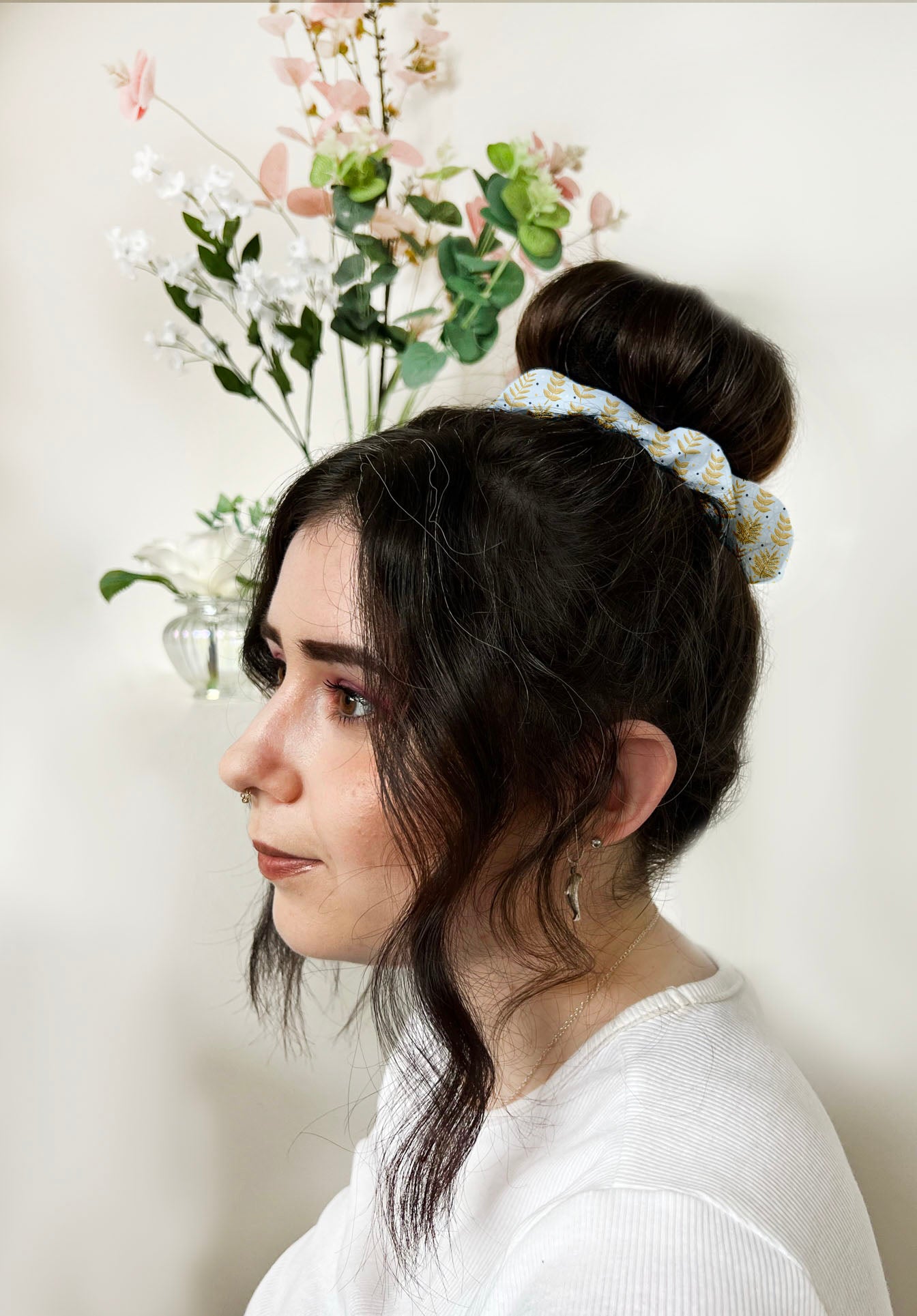 dark haired girl wears yellow patterned scrunchie around a bun